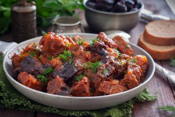 Beef with prunes in tomato sauce in a pan, horizontal