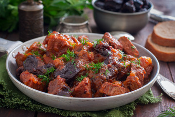 Beef with prunes in tomato sauce in a pan, horizontal