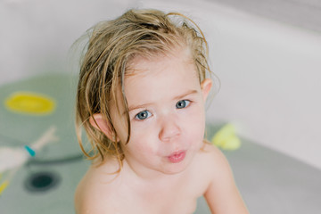 Portrait of a little girl bathing in a bath