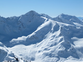 Fototapeta na wymiar Snow-capped mountain peaks of mount Cheget bright Sunny day