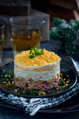 Salad in layers with canned champignons, smoked chicken and cheese, selective focus