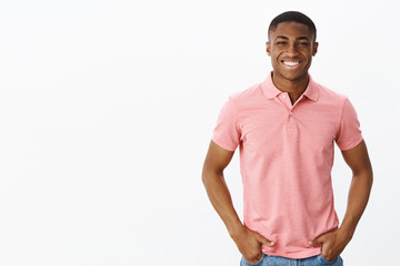 Waist-up shot of attractive positive and happy young african american male entrepreneur in pink...