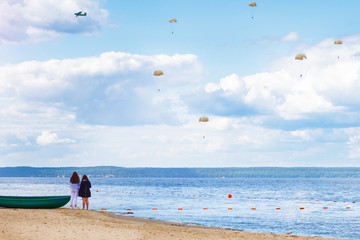 Obraz premium Parachutists in the sky over the river.