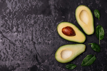 Food, avocado, healthy food. Cut by avocado against a dark background. It can be used as a background