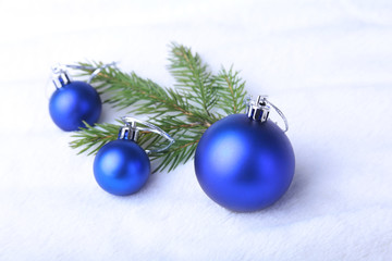 Merry Christmas background with blue balls, christmas tree on snow with snowflakes falling from a blue sky.