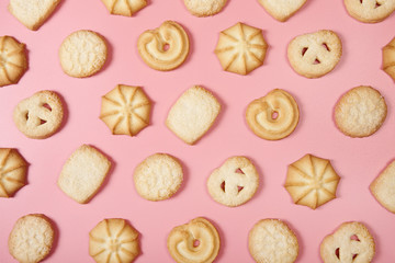 Danish butter cookies on pink background, top vew.