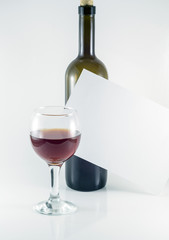  Glass and bottle of red wine with white sheet for text on white background