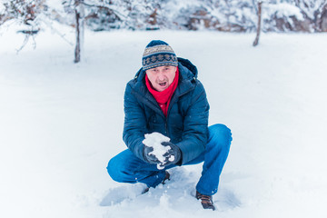 People 50-60 years enjoy the life, season of christmas time, winter and snow concept - close up of man with snowball 