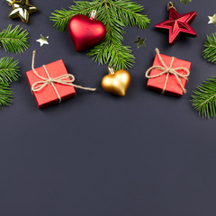 Festive Christmas background with fir branches, presents, decorations on black, copy space