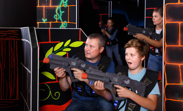 Positive boy and his father aiming laser guns