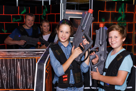 Ordinary boy and girl posing with laser guns