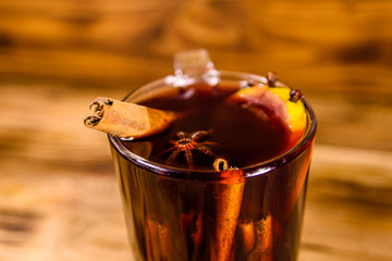 Cup of mulled wine with cinnamon on wooden table