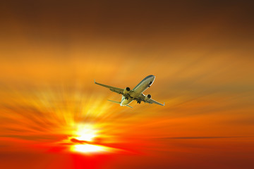 Fototapeta na wymiar Airplane on sunrise background