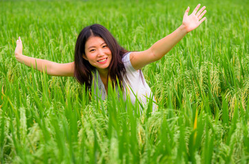 young beautiful and happy Asian Korean tourist girl having fun feeling free at tropical rice field enjoying exotic holidays trip in Asia exploring traditional village