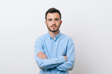 Photo of seriously man in blue shirt with crossed hands