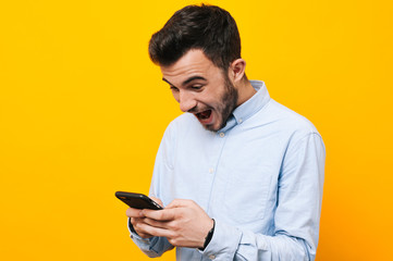 Portrait of excited young man that playing games on smartphone