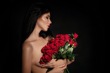beautiful young woman with a large bouquet of red roses