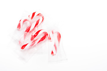 Candy canes in plastic wrappers on a white background
