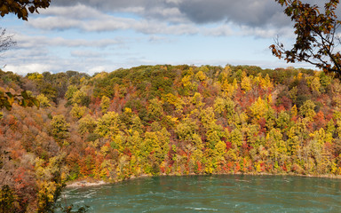 Niagara Whirlpool.  The view across Niagara Whirlpool located on the Canadian and American border.  In the background can be seen the colorful foliage of trees during the fall.