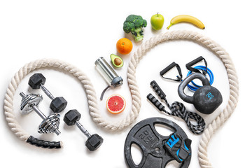 Sports equipment and organic food on a white background. Top view. Motivation