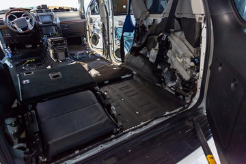 Tuning the car in a SUV body with three layers of noise insulation on the floor. Sound and vibration isolation using soft and pimply material with a car breakdown.