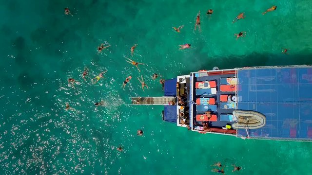 Aerial view of people in ferry diving on the sea, Ithaki island, Greece.