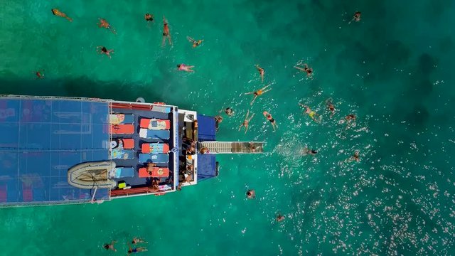 Aerial view of people in ferry diving on the sea, Ithaki island, Greece.