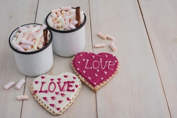 Romantic breakfast for valentine day. A delicious drink of marshmallows and heart-shaped cookies. Breakfast for lovers on a white  wooden table