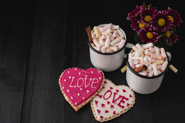Romantic breakfast for valentine day. A delicious drink of marshmallows and heart-shaped cookies. Breakfast for lovers on a wooden table