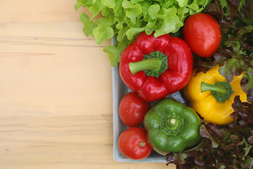 Top view of organic fresh vegetables in ceramic plate on wooden table. Preparation for healthy food. 