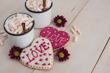 Romantic breakfast for valentine day. A delicious drink of marshmallows and heart-shaped cookies. Breakfast for lovers on a white  wooden table