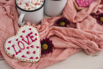 Romantic breakfast for valentine day. A delicious drink of marshmallows and heart-shaped cookies. Breakfast for lovers on a white table with pink textile