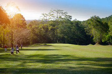 The evening golf course has sunlight shining down at golf course in Thailand