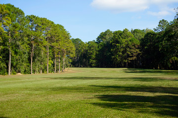 The evening golf course has sunlight shining down at golf course in Thailand