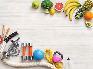 Sports equipment and healthy food on a white wooden background. Top view. Motivation