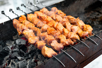 Appetizing pork shish kebab. Shashlik preparing on barbecue grill over charcoal outdoors. Selective focus