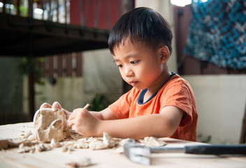 A young boy digging educational fossil in the garden