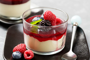 Delicious italian dessert panna cotta with berry sauce, fresh berries and mint on gray background. - Image