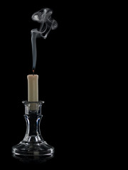 The extinguished candle in a glass candlestick