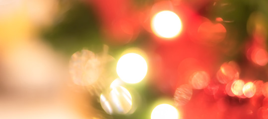 Christmas bokeh blur background with blurry x’mas tree party night light decoration ornate in warm red green gold color for holiday greeting card backdrop