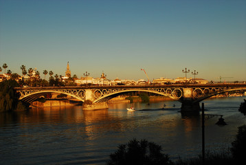 sunset in seville, along the guadalquivir river, in the popular neighborhood of triana