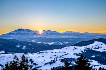 Imponujący wschód słońca w górach podczas mroźniej i śnieżnej zimy