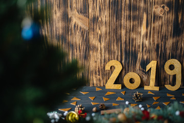 The inscription 2019 on the background of New Year's decorations on a wooden background