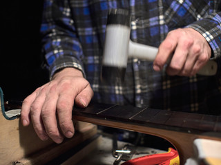 Installation frets on the neck of the guitar.