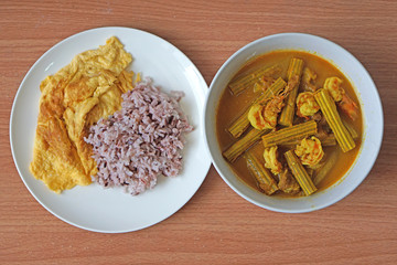 Thai hot sour and spicy soup of Drum stick tree's pod seed and shrimp with brown rice and scramble egg