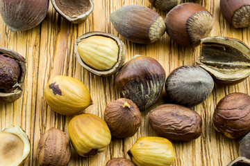 Broken nuts lie on a brown  wooden background.