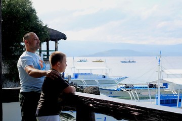 Father and son watching boats at sea