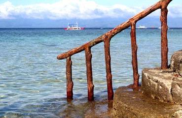 Ladder in the sea against the sky and the sea with boats