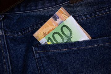 euro bills sticking out of the back jeans pocket