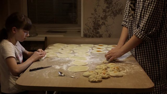 Women bake pies. Making buns. Dough on the table. Knead the dough.